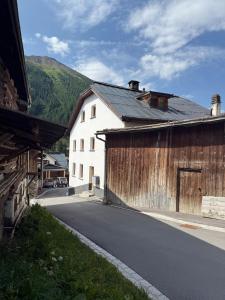 an empty road next to a large wooden building at Ferienwohnung mit Kamin und Balkon in Samnaun