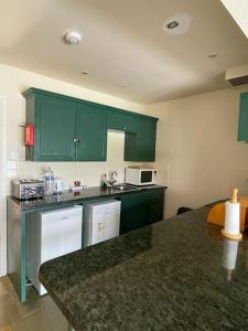 a kitchen with green cabinets and a counter top at Lochside Apartment in Moffat