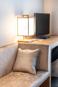 a desk with a computer monitor on top of a couch at KIORI Hotel Takakura in Kyoto