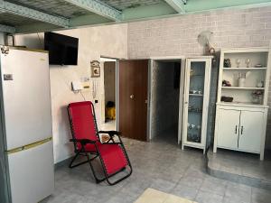 a room with a red chair in a room at Dolci Momenti Rooms in Torre Annunziata
