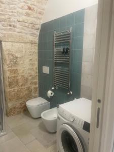 Un baño con lavadora y un inodoro. en casa diamantik 2, en Martina Franca
