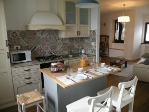 a kitchen with a counter with chairs and a table at Il Nido nel Borgo in Valfabbrica