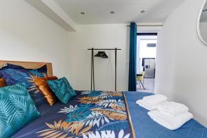 una camera da letto con un letto con asciugamani sopra di Maison des As - Pays de Champagne a Épernay