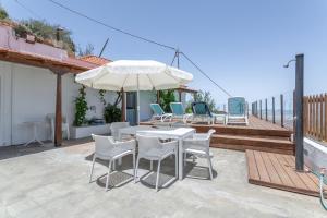 a patio with a table and chairs and an umbrella at Casa Mica Relax y Naturaleza in Vega de San Mateo
