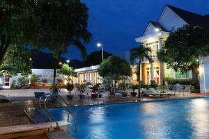 a swimming pool in front of a building at night at gold star homestay in Long Hai