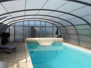 a swimming pool in a building with a glass ceiling at La Chanterelle - Gites Rocheflamme in La Malène