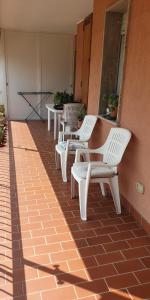 a row of white chairs sitting on a patio at Ca da Simo in Albenga