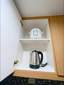 a tea kettle is sitting in a cupboard at Shell Residence Tower A 250A in Manila