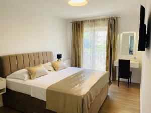 a bedroom with a bed and a desk and a window at Villa Tajnikov in Hvar