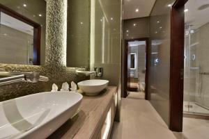 a bathroom with a large sink and a shower at Bahrain Airport Hotel Airside Hotel for Transiting and Departing Passengers only in Muharraq