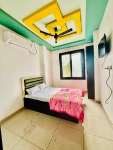 a bedroom with a bed with a ceiling fan at Hotel Prince Cafe & Restaurant in Shāhpura