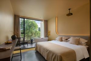 1 dormitorio con 1 cama y baño con ventana en West Desert Luxury Holiday Homestay, en Dunhuang