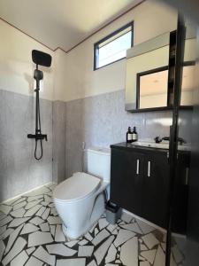 a bathroom with a toilet and a sink at Ullasa Villa Dieng in Diyeng