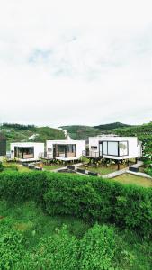 a group of white buildings on a grass field at Ullasa Villa Dieng in Dieng