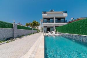 a house with a swimming pool in front of a building at Villa Lolivia in Belek
