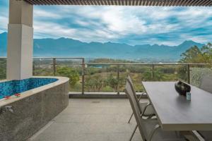 d'un balcon avec une table et une vue sur les montagnes. dans l'établissement GANGZHOU BENZYOO B&B（ Baishuizhai Skov River）, à Huangshadang