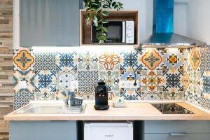 Una cocina con fregadero y pared de azulejos. en Reyes Albaicín, en Granada 210 fotos más