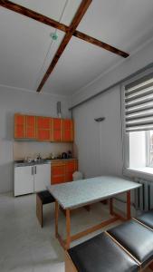 a kitchen with orange cabinets and a table in a room at Arita in Pļaviņas