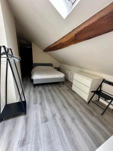 a bedroom with a bed and a dresser in a attic at Duplex au centre de Fontainebleau vivez en plein cœur de la ville in Fontainebleau