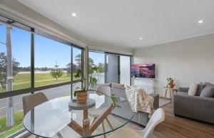 a living room with a glass table and a couch at Driftwood Townhouse - Waterfront-Central Location in Lakes Entrance