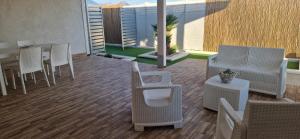 a patio with wicker chairs and a table and a table and chairs at Podilimbo - Ilios e Thalassa in Paestum