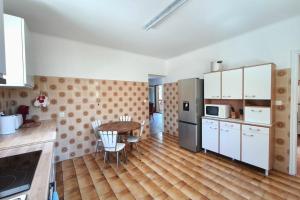 a kitchen with a wooden floor and a table in it at Family house with garden near the sea in Porticcio