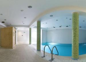 uma piscina num quarto com duas colunas em Bursztyn Spa em Kolobrzeg