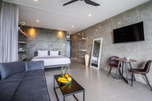 a bedroom with a bed and a living room with a couch at Brand new apartment with stunning sunset views in Munggu