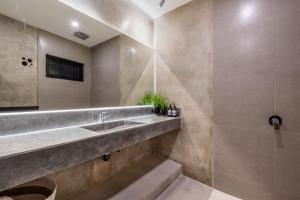 a bathroom with a sink and a shower at Brand new apartment with stunning sunset views in Munggu +8 photos
