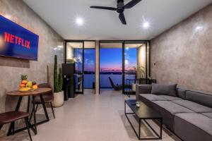 a living room with a couch and a tv at Brand new apartment with stunning sunset views in Munggu