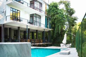 a building with a swimming pool in front of a building at Sunwin River Cabana & Hotel in Udawalawe