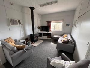 a living room with two couches and a stove at Kandos Cottage in Kandos