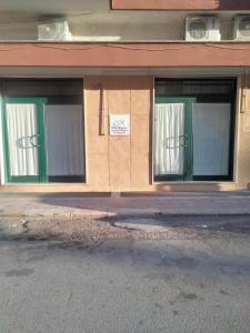 a building with three windows and a sign on it at Dolce Riposo in Trani