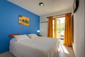 a bedroom with a white bed and a blue wall at Hotel Estalagem Porto Seguro in Porto Seguro +41 photos