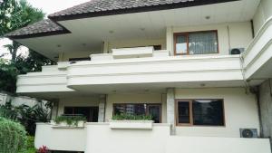 a white house with potted plants on it at The Sinabung Residence Jakarta in Jakarta