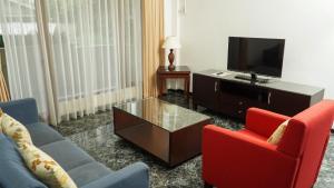 a living room with two chairs and a tv at The Sinabung Residence Jakarta in Jakarta
