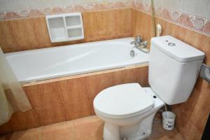 a bathroom with a toilet and a bath tub at The Sinabung Residence Jakarta in Jakarta +6 photos