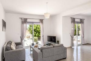 a living room with two couches and a tv at Villa Orange Tree in Lachi