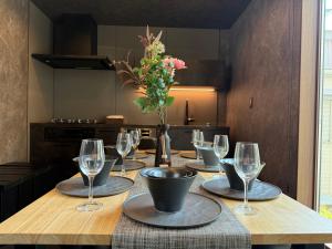 a table with wine glasses and a vase with flowers at EKVOLI ROPPONGI TOKYO, Private Hotel in Tokyo