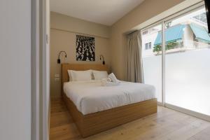 a bedroom with a bed and a large window at Incanto Boutique Suites - Koukaki in Athens