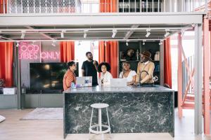 a group of people standing around a counter with laptops at Campus House by Larsen in Tallinn