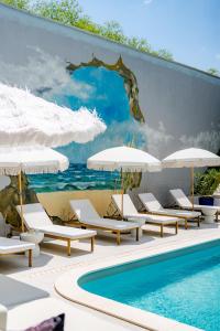 a mural of a swimming pool with lounge chairs and umbrellas at Zen Vama Veche in Vama Veche