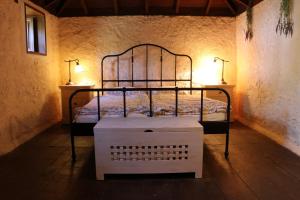 ein Metallbett in einem Zimmer mit zwei Lampen in der Unterkunft El Cortijo in Garafía