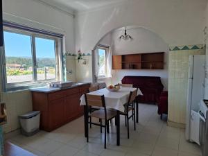 a kitchen with a table and a room with a bed at Casa do Vale in Arrabal