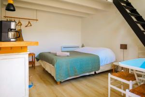 Cet appartement comprend une chambre avec deux lits, une table et une cuisine. dans l'établissement Joli studio au calme au cœur des Sables d'Olonne - 4 personnes, à Les Sables-dʼOlonne