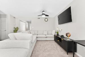 een woonkamer met een witte bank en een tv bij Styling Gem 5mins to Downtown pool-gym-parking in Durham