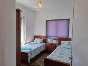 a bedroom with two beds and a purple window at Casa do Vale in Arrabal