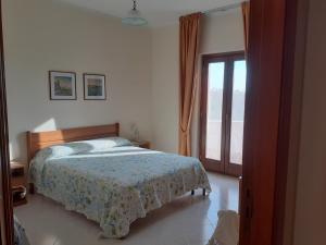 a bedroom with a bed and a large window at B&B Le Ginestre in Foria
