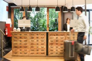 a man and woman standing at a counter in an office at Arenas Atiram Hotel in Barcelona