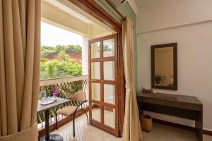 a room with a balcony with a door and a mirror at The Palm House - Coworking and Coliving Community in Canacona